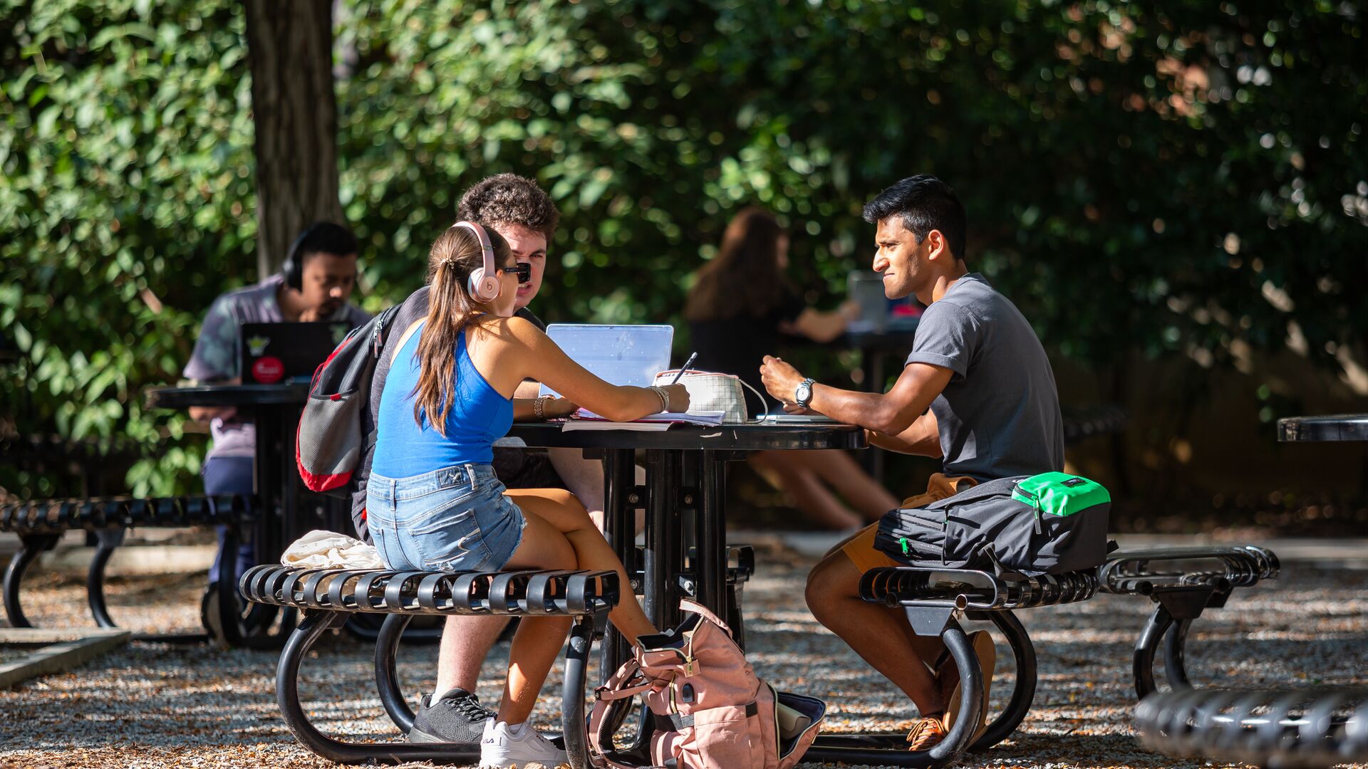 students working at an outdoor table 