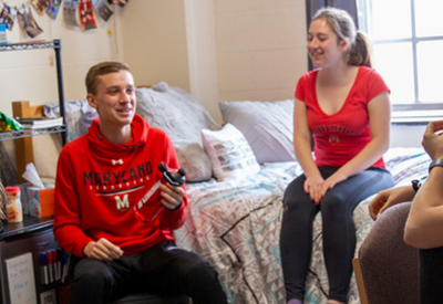 group of students talking in dorm room