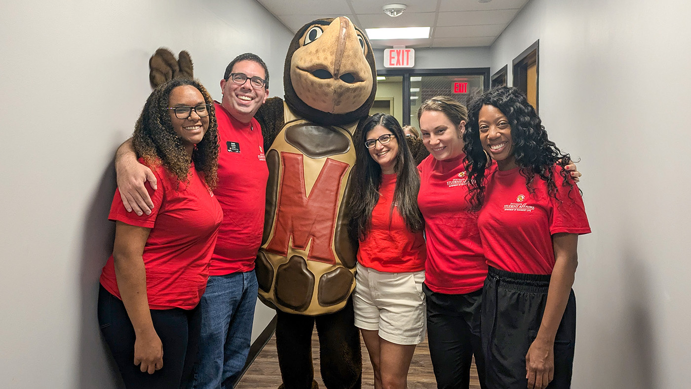 res life engagement staff wearing red shirts with testudo in the hallway