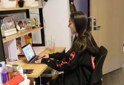 student working at desk in dorm room