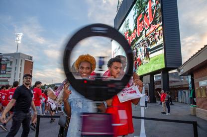 Two students pose at a "360-degree" photo booth during the Big Show event at the football stadium.
