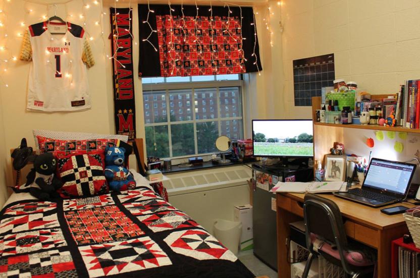 single room with a bed, desk and red decorations