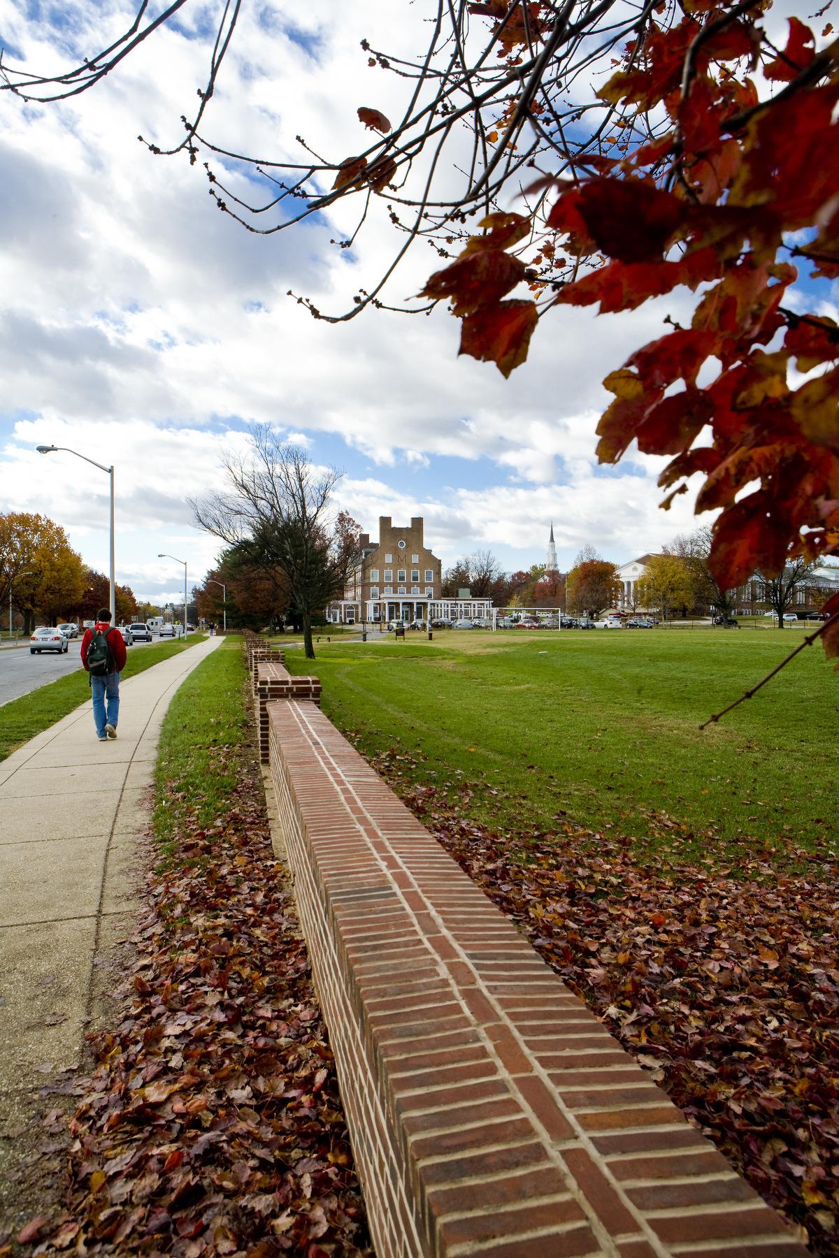 student walking on sidewalk near route 1