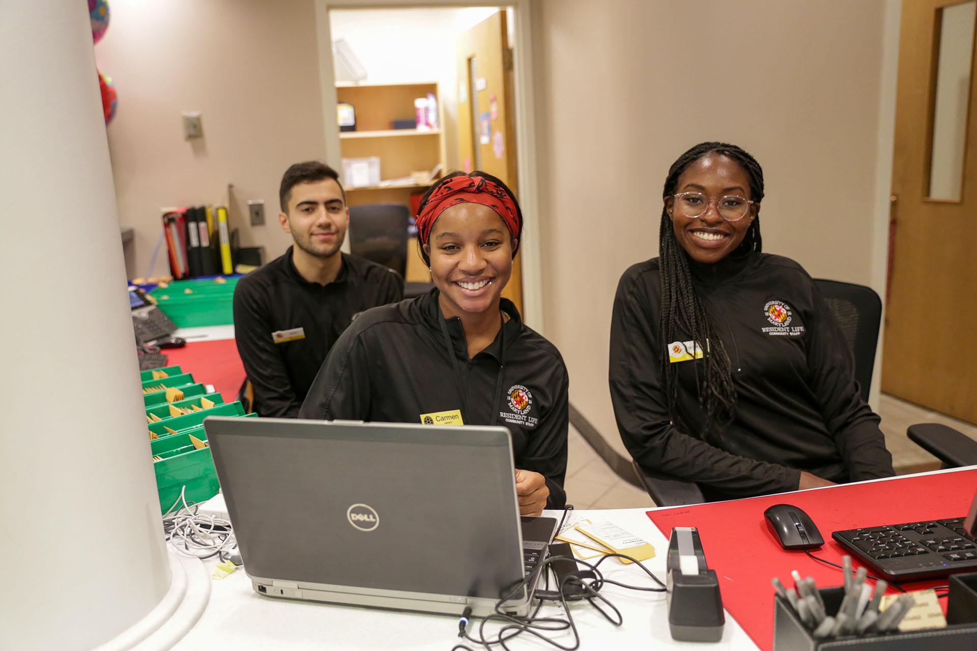 three community assistants at a service desk