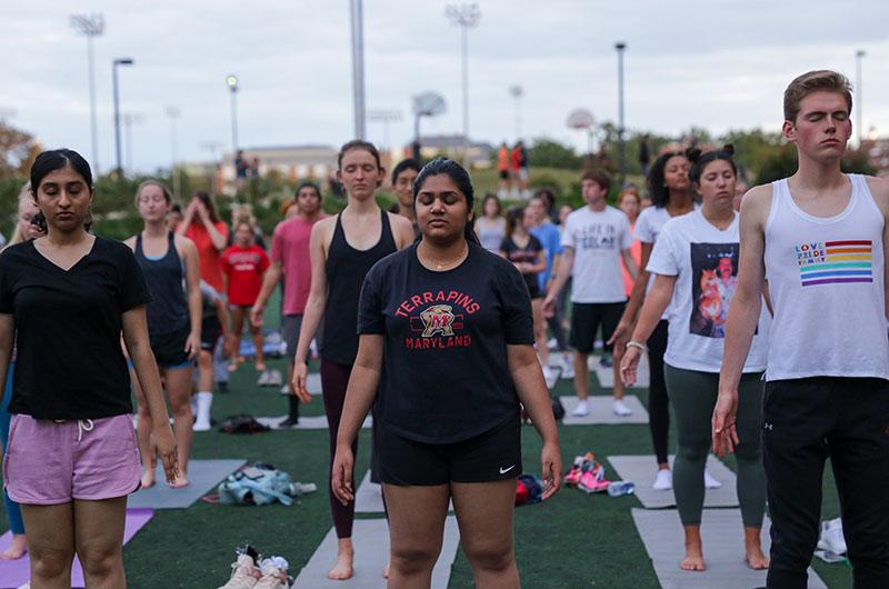 students practicing yoga at sunset outdoors