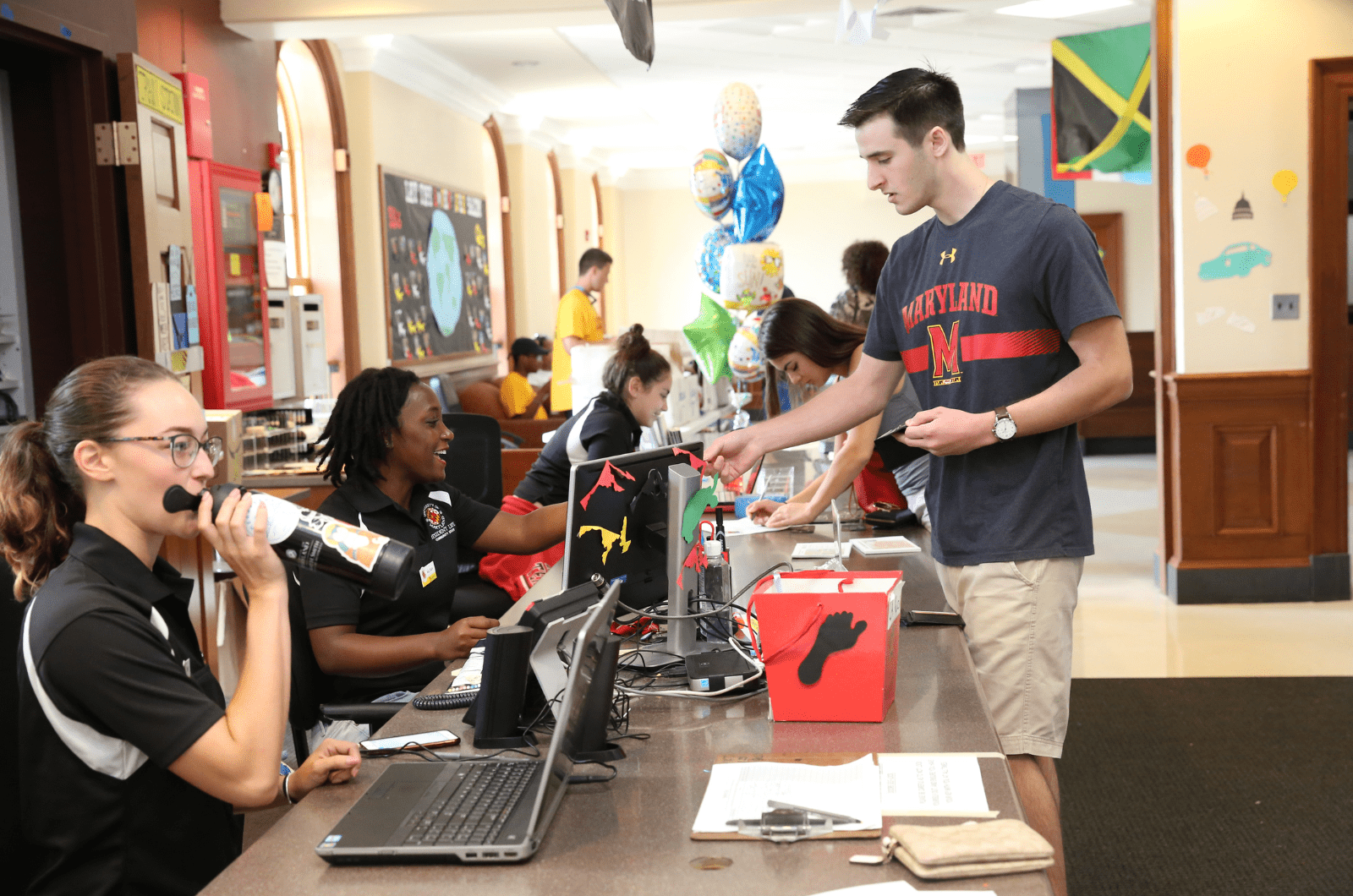 student staff at service desk handing key to a resident