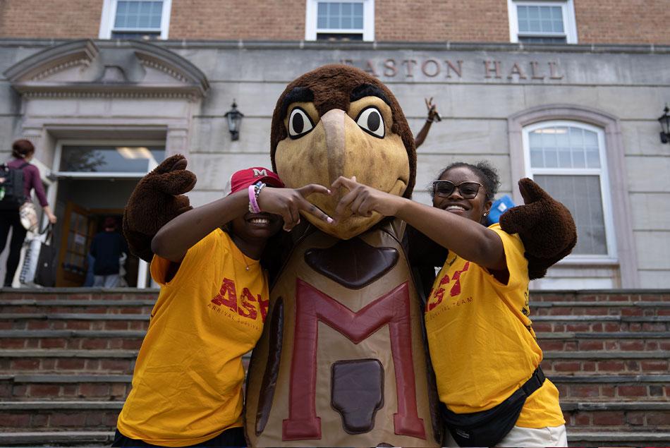 testudo mascot with two student volunteers in front of Easton Hall during fall move-in