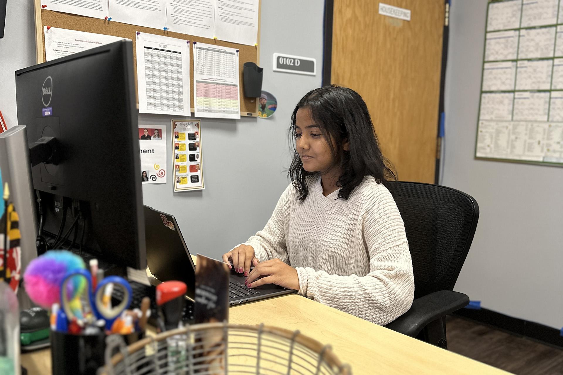 program assistant working at desk in the Residential Engagement office suite