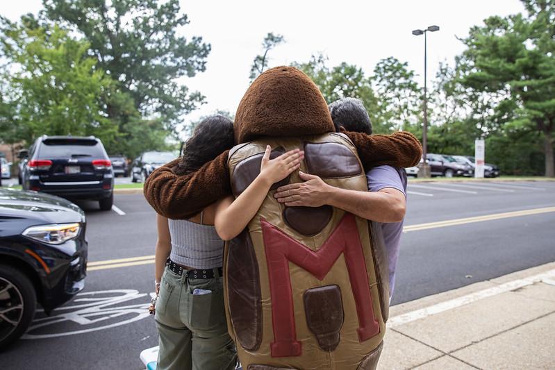 Testudo mascot hugging family during fall move-in