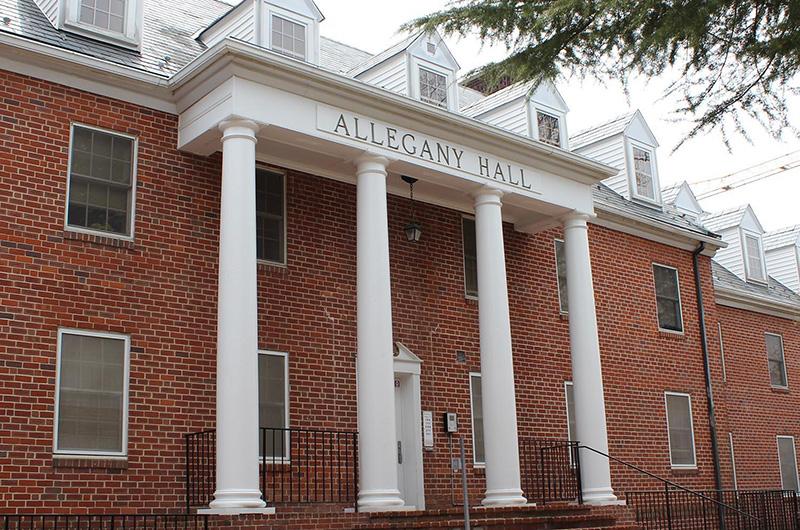 Exterior of Allegany Hall, a brick residence hall with large white pillars and roof dormers.