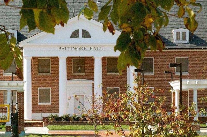 Exterior of Baltimore Hall, a brick residence hall with white columns and a pediment at the entrance.
