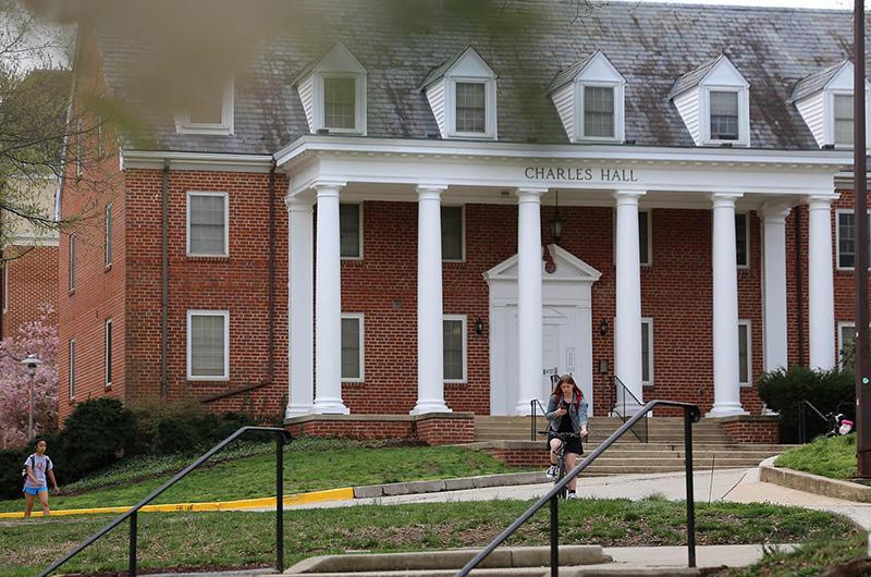 Exterior of Charles Hall, a brick residence hall with a white pillared porch and roof dormers.