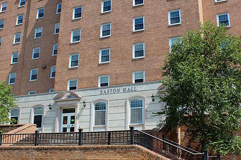 Exterior of brick Easton Hall with stone entryways and steps leading to the main entrance.