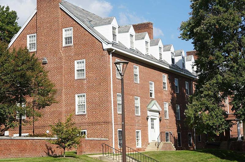 Exterior of Prince George's Hall, a three-story brick residence hall with white-trimmed roof dormers.
