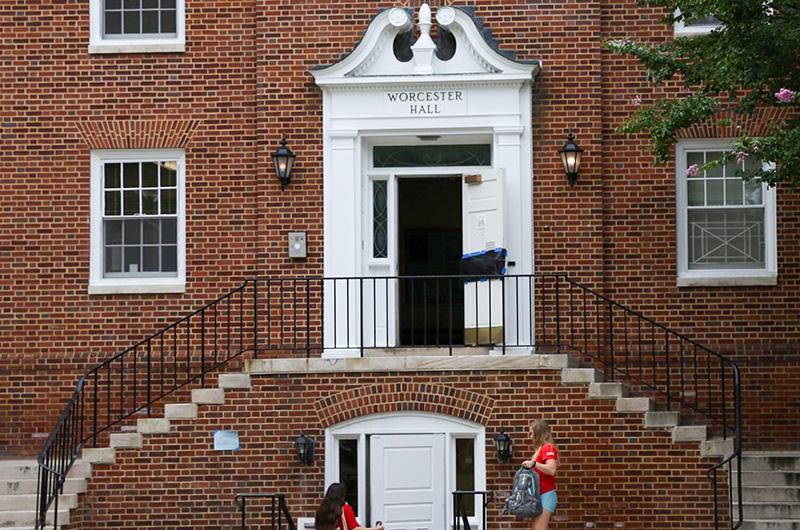Exterior of Worcester Hall, a brick building with a white decorative entrance and curved brick staircases.