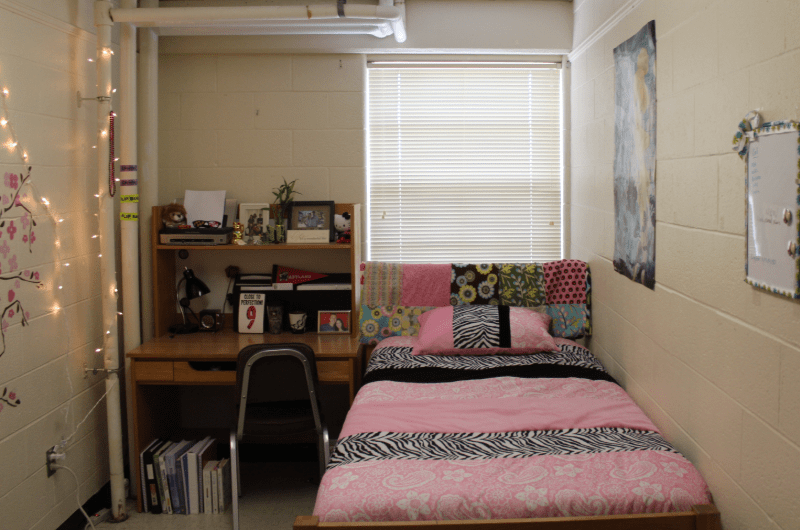 A traditional single room with bed and table and chair