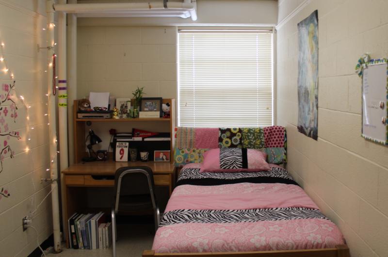 A traditional single room with bed and table and chair