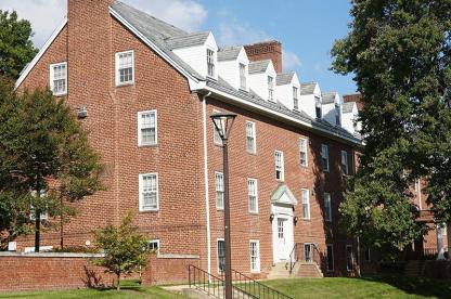 Exterior of Prince George's Hall, a three-story brick residence hall with white-trimmed roof dormers.